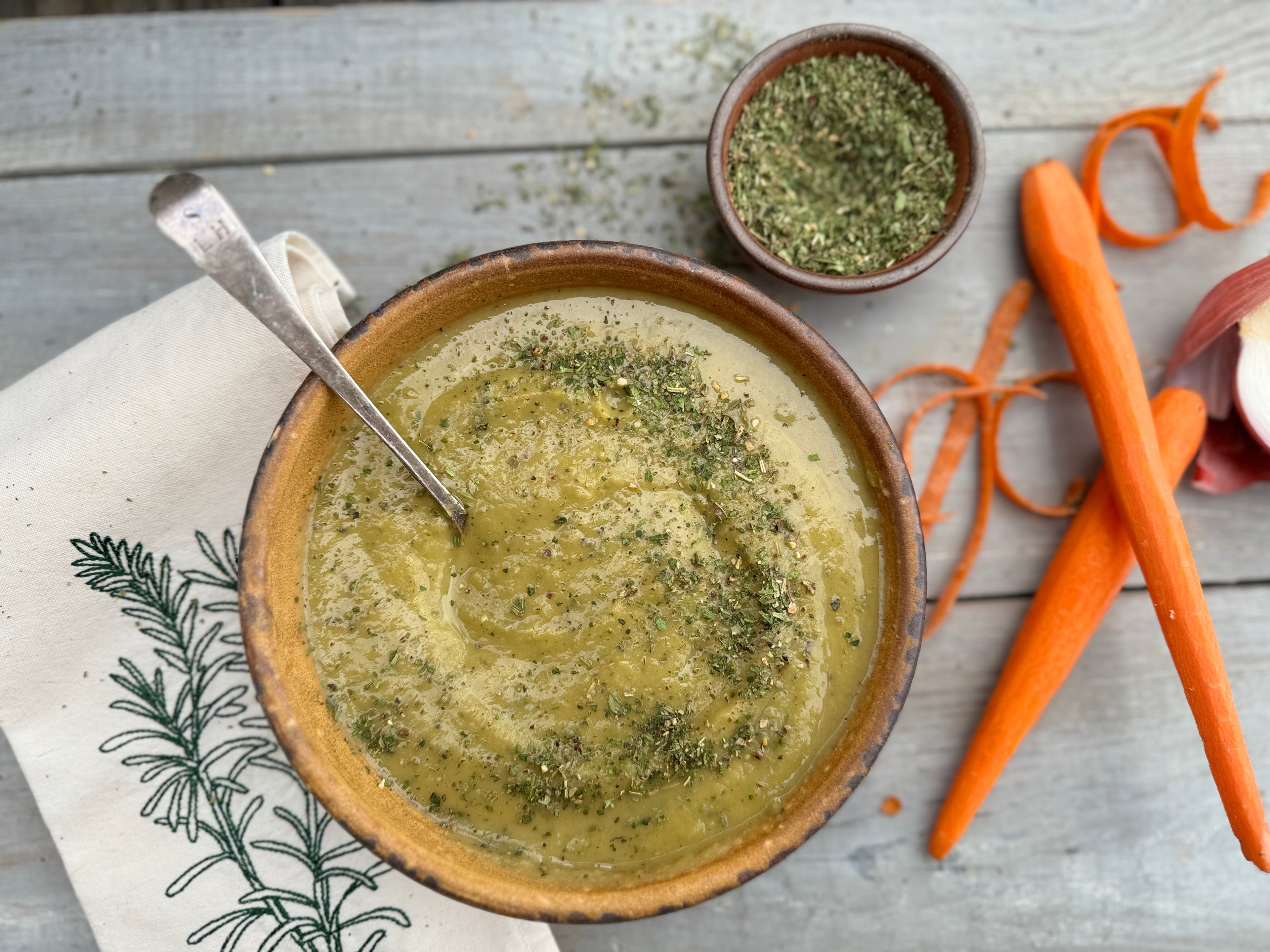 split pea soup, carrots, napkin, spoon, brown bowls