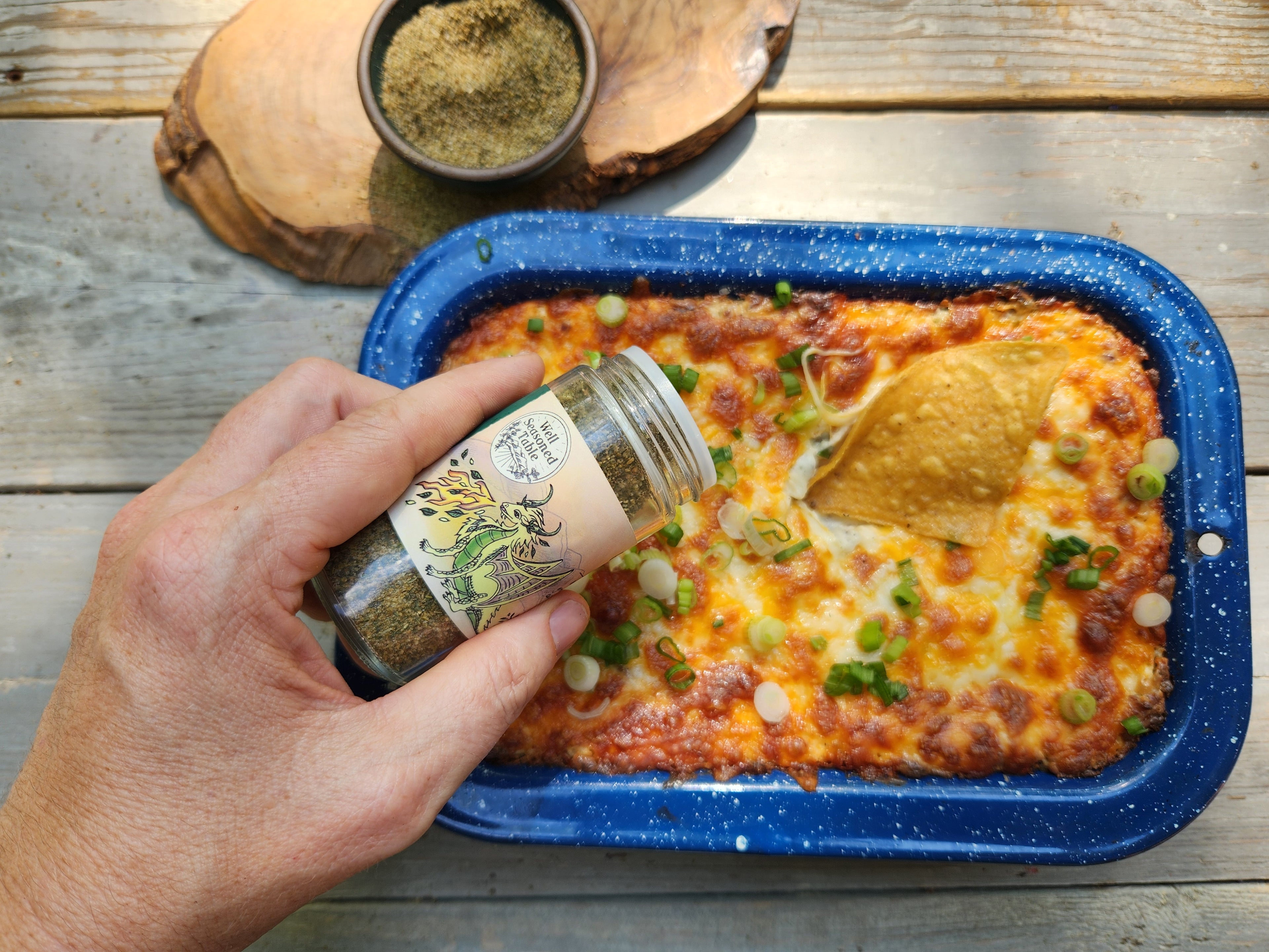Jalapeño Popper Dip with Well Seasoned Table Green Dragon Dust in a Blue Bake Dish