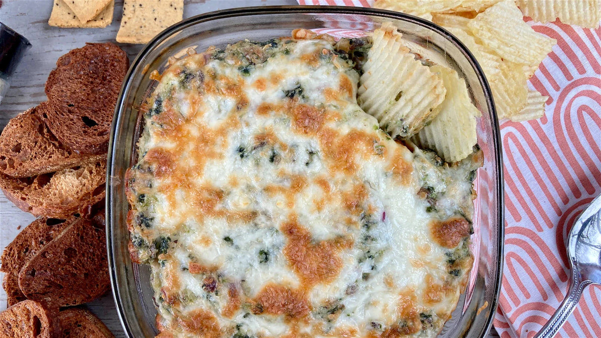 cheesy spinach and mushroom dip in a glass dish, well seasoned table, magic garlic dust