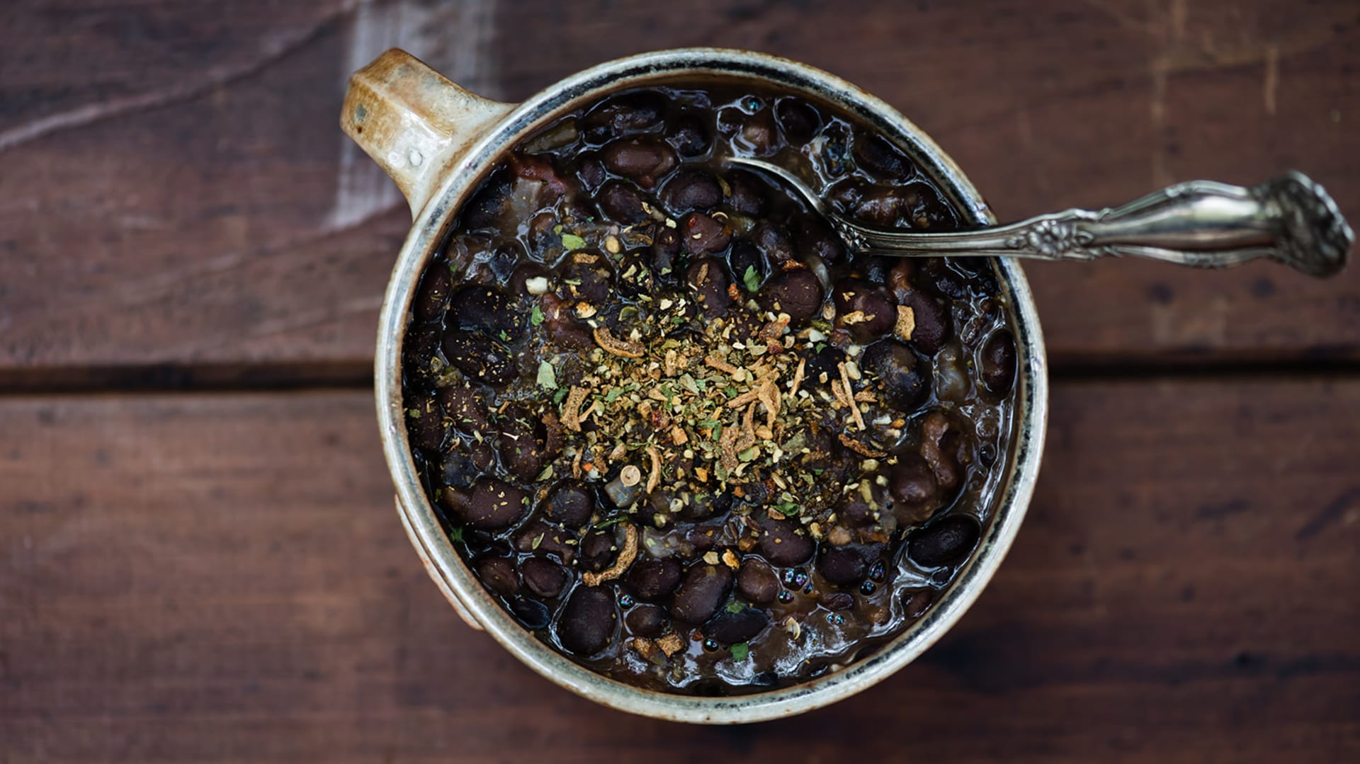 A mug of black beans with cuban seasoning sprinkled over the top