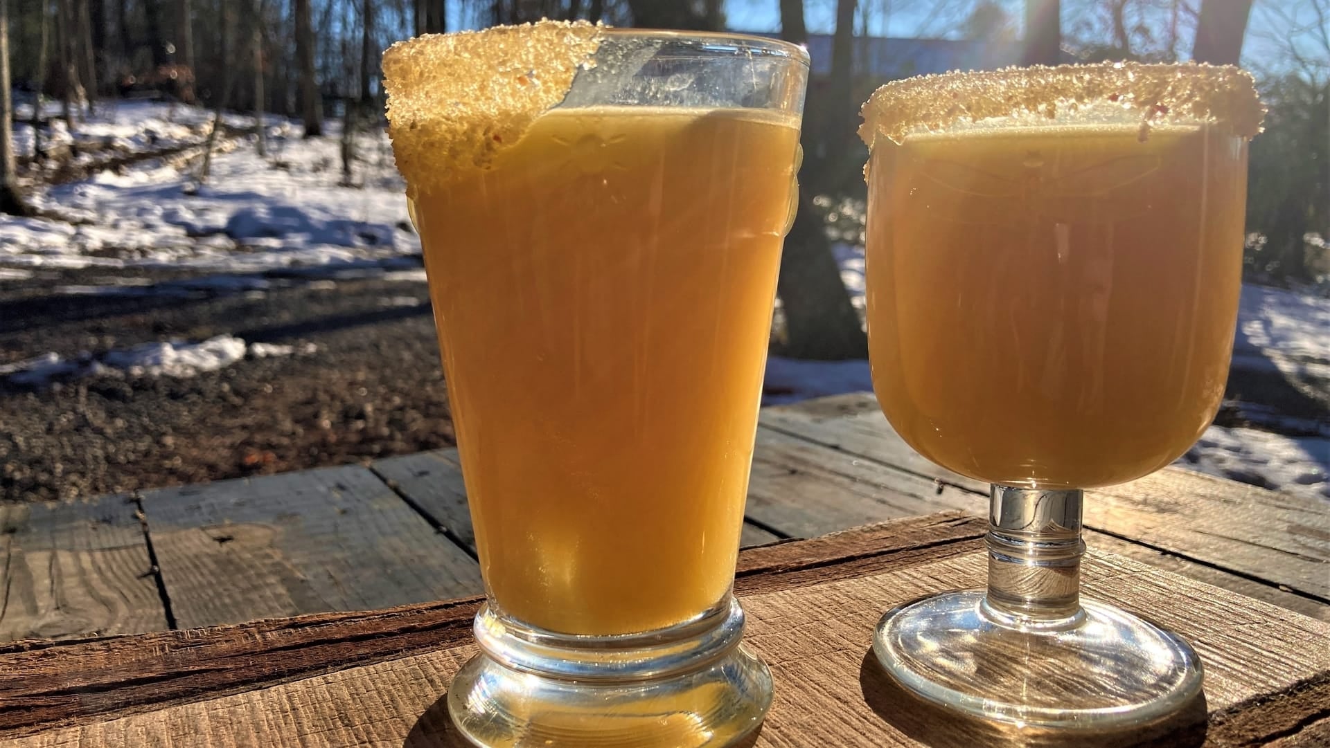 A mason jar of pineapple margarita with a sugar rim of Candied Jalapeno Sugar from Well Seasoned Table