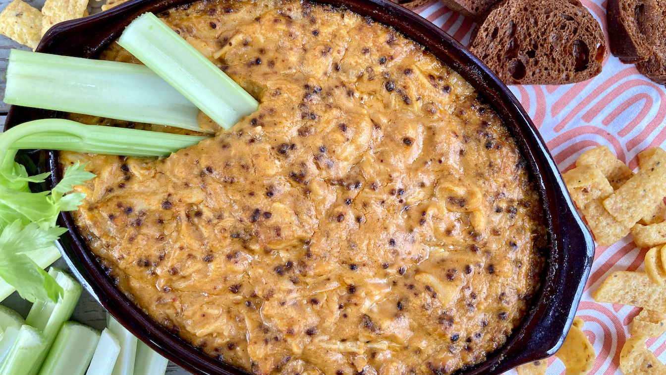 Smoky Buffalo Chicken Dip with celery, crostini's, and chips around it for dipping. 