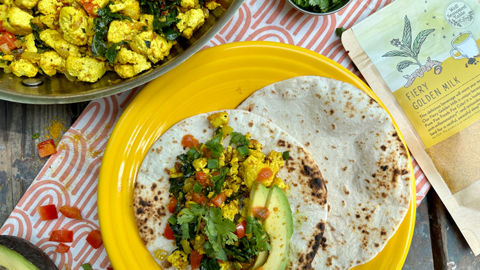 Breakfast Tacos on a yellow plate, on a outdoor table with napkin