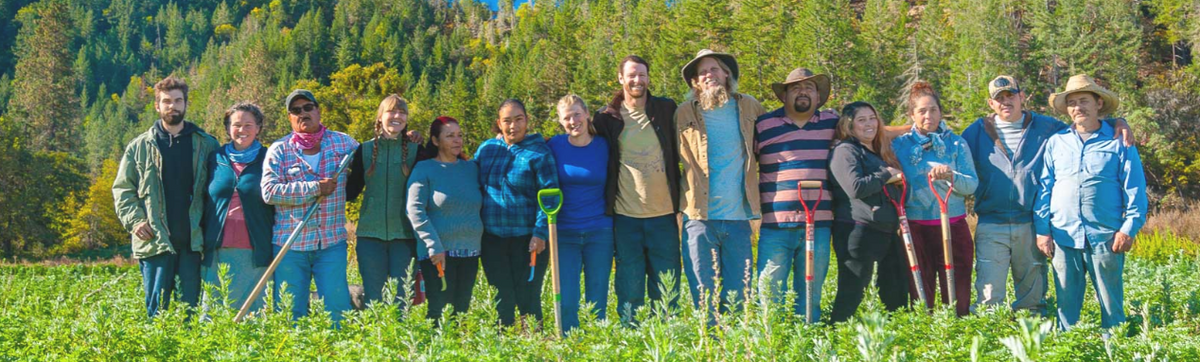 Oshala Farm Crew standing side-by-side in a field of herbs