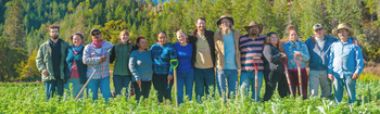 Oshala Farm Crew standing side-by-side in a field of herbs
