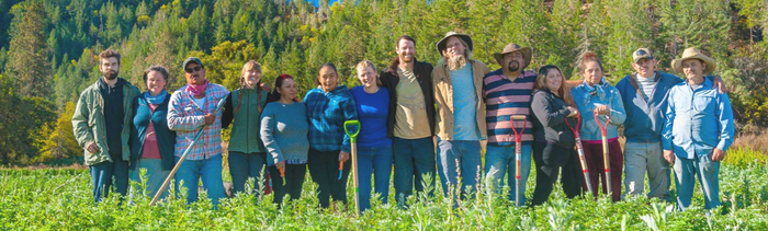 Oshala Farm Crew standing side-by-side in a field of herbs