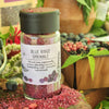 Bottle of Blue Ridge Sprinkle surrounded by an assortment of fresh berries and green herbs