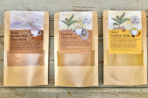 Powdered beverage mixes from Well Seasoned Table in packets on a wooden background.